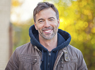 man in jacket smiling outside