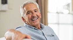 man smiling while sitting on couch 