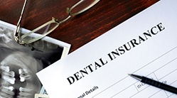 A dental insurance form placed on a brown and wooden table
