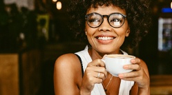 person smiling and drinking coffee